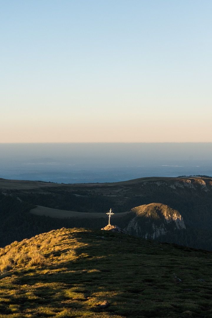 croix dorée au sommet d'une montagne