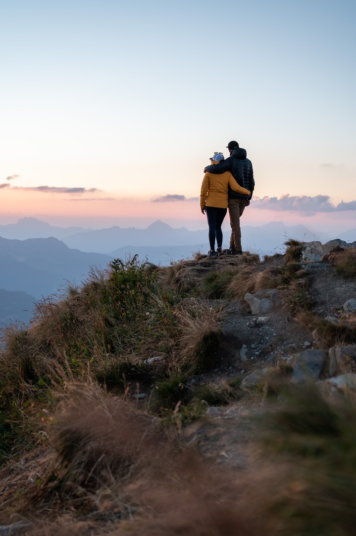 couple face au coucher de soleil sur le mont coin