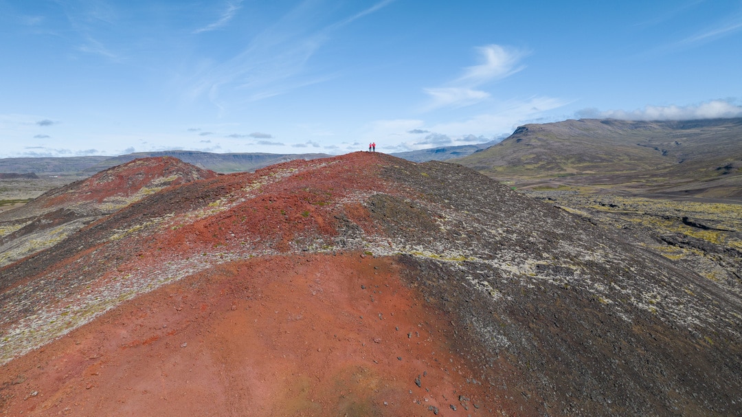 randonneurs au sommet d'un volcan rouge