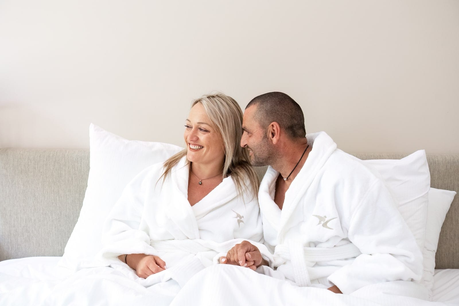 couple en peignoir dans un lit hôtel