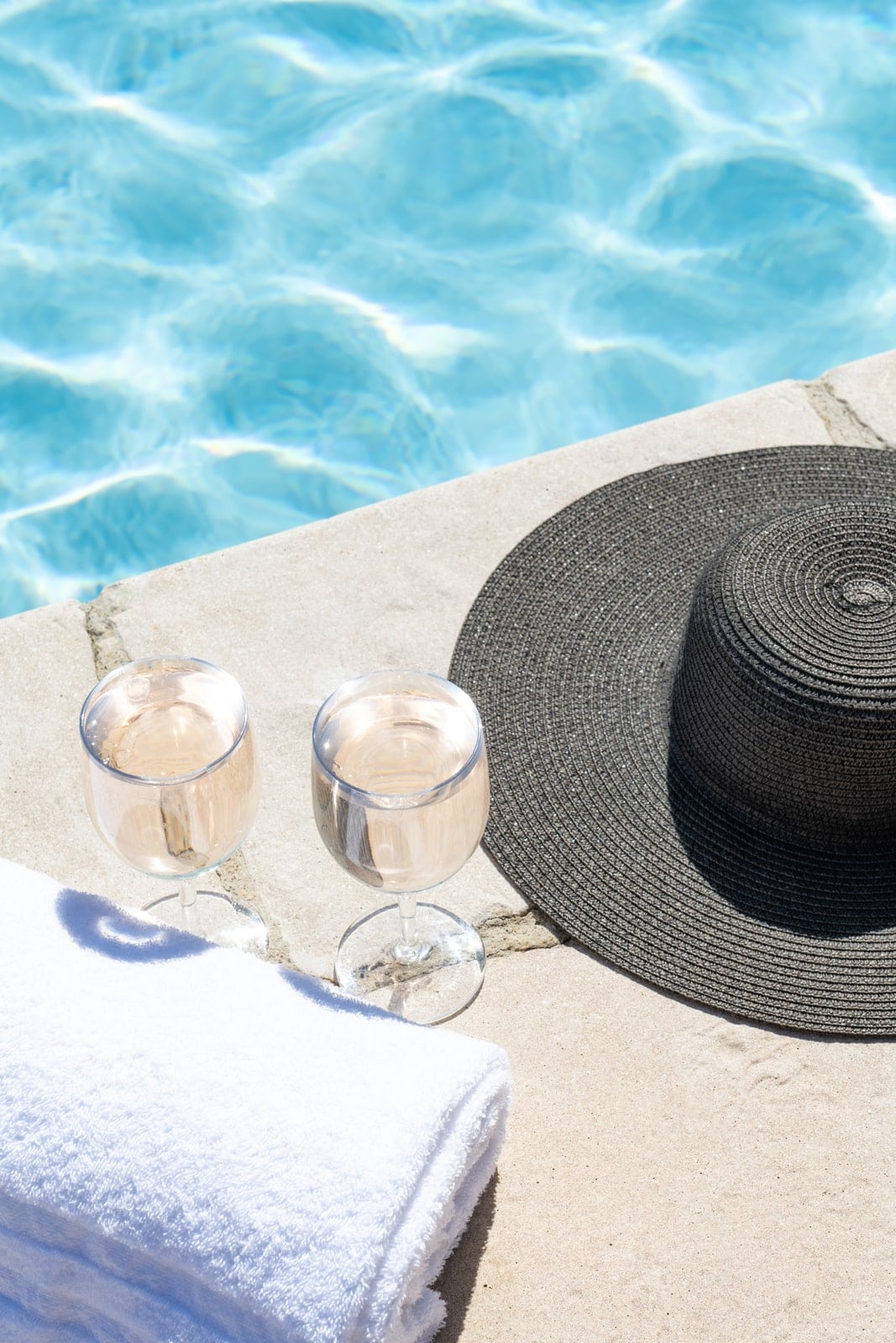 verres, serviette et chapeau en bord de piscine