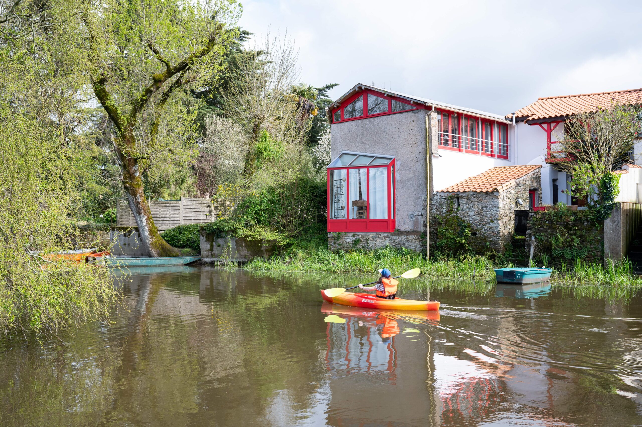 canoe sur riviere devant maison